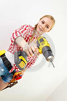 Woman using drill on wall
