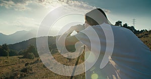 Woman using DSLR camera on tripod photographing mountain landscape