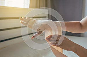 Woman using elastic bandage with hand,Female putting bandage on his injured hand