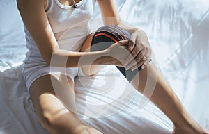 Woman using elastic bandage with leg,Female putting bandage on her injured knee