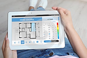 Woman using energy efficiency home control system on tablet