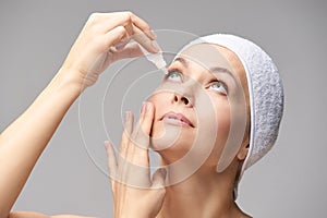 Woman using eye drops. Medicine treatment. Eyecare human problem. Ophtalmology dropper photo