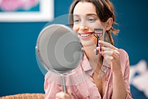 Woman using eyelash curler