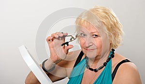 Woman using eyelash curler.