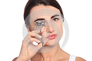 Woman using eyelash curler on background