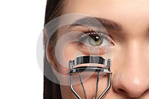 Woman using eyelash curler on white background, closeup