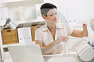 Woman using fax machine