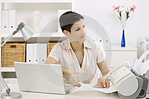 Woman using fax machine