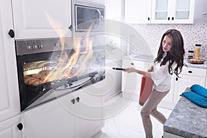 Woman Trying To Stop Fire Coming Out From Oven