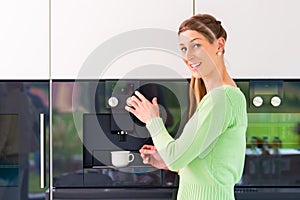 Woman using fully automatic coffee machine