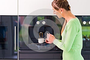 Woman using fully automatic coffee machine