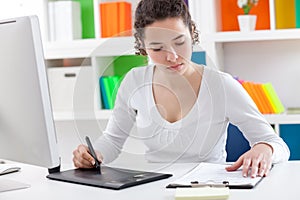 Woman using a graphic tablet and pen