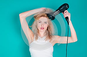 Woman using hair dryer. Young girl with drying hair with hair dry.