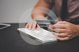 Woman is using a hand typing keyboard and uses a modern credit card by laptop or smartphone