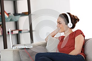 Woman using headphones and laptop