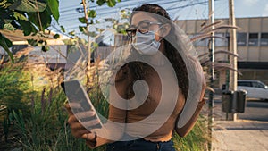 Woman using her cell phone wearing a mask