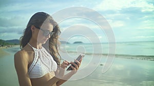 Woman Using Her Mobile Phone.On The Beach