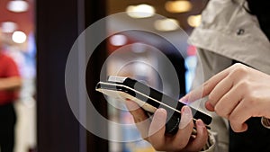 Woman using her mobile phone on beautiful blurred lighting background inside Mcdonalds restaurant