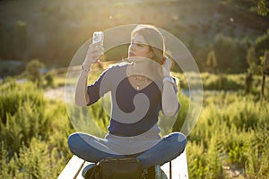 Woman using her mobile phone outdoors in nature