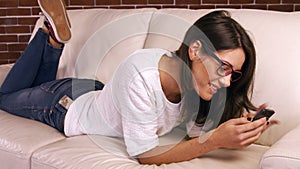 Woman using her phone on sofa