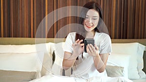 Woman using her smartphone on bed