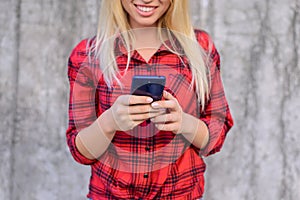 Woman using her smartphone for surfing the internet, she is watching funny videos on the internet. Young girl with beaming smile