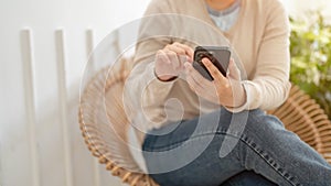 A woman using her smartphone to chat with her friends while relaxing in a minimalist cafe