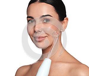 Woman using high frequency darsonval device on white background