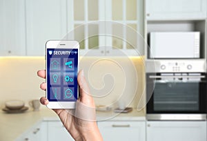 Woman using home security app indoors. Space for text