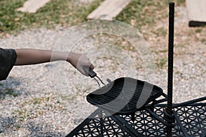 A woman is using a hot pan to grill something during camping