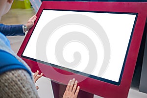 Woman using interactive empty white touchscreen display kiosk at exhibition