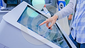 Woman using interactive touchscreen display kiosk