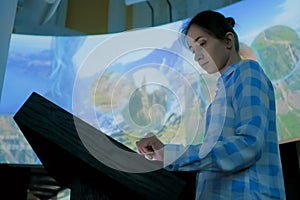 Woman using interactive touchscreen display at modern history museum