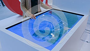 Woman using interactive touchscreen display table