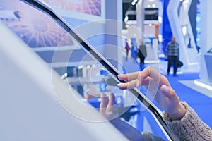 Woman using interactive touchscreen display at technology exhibition