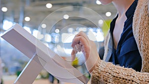 Woman using interactive touchscreen display at urban exhibition