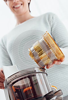Woman using a juice extractor photo