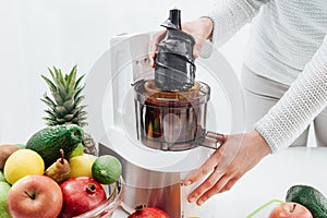 Woman using a juice extractor photo