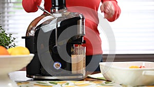 Woman using juicing machine at home