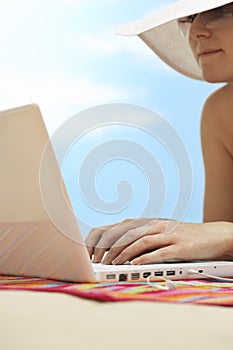 Woman Using Laptop On Beach