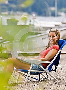 Woman using laptop on beach