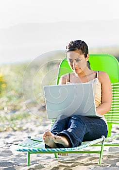 Woman using laptop at beach