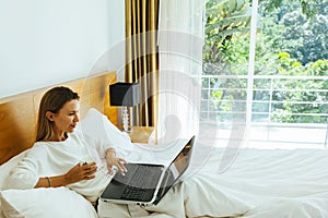 Woman using laptop in the bed