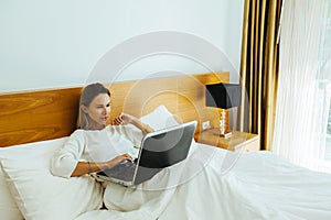 Woman using laptop in the bed