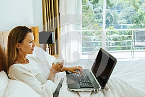 Woman using laptop in the bed