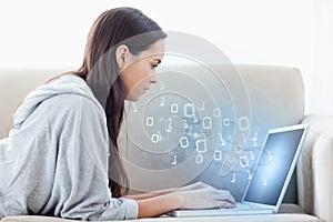 Woman using laptop with binary codes floating over