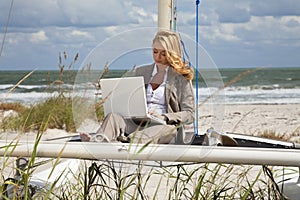 Woman Using Laptop On Boat At The Beach