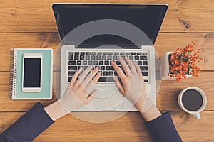 Woman using laptop in coffee shop, close-up