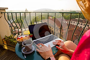 Woman using laptop computer on balcony