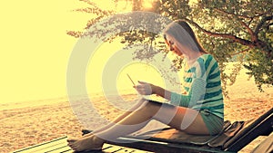 Woman using laptop computer on a beach